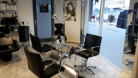 De kapsalon van binnen, met de kappersstoelen bij de etalage